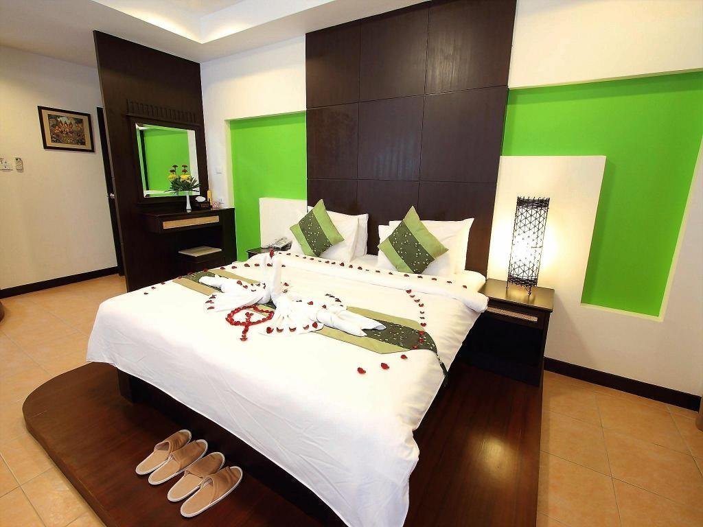 Bedroom with green accent walls at Royal Nakara Ao Nang Hotel